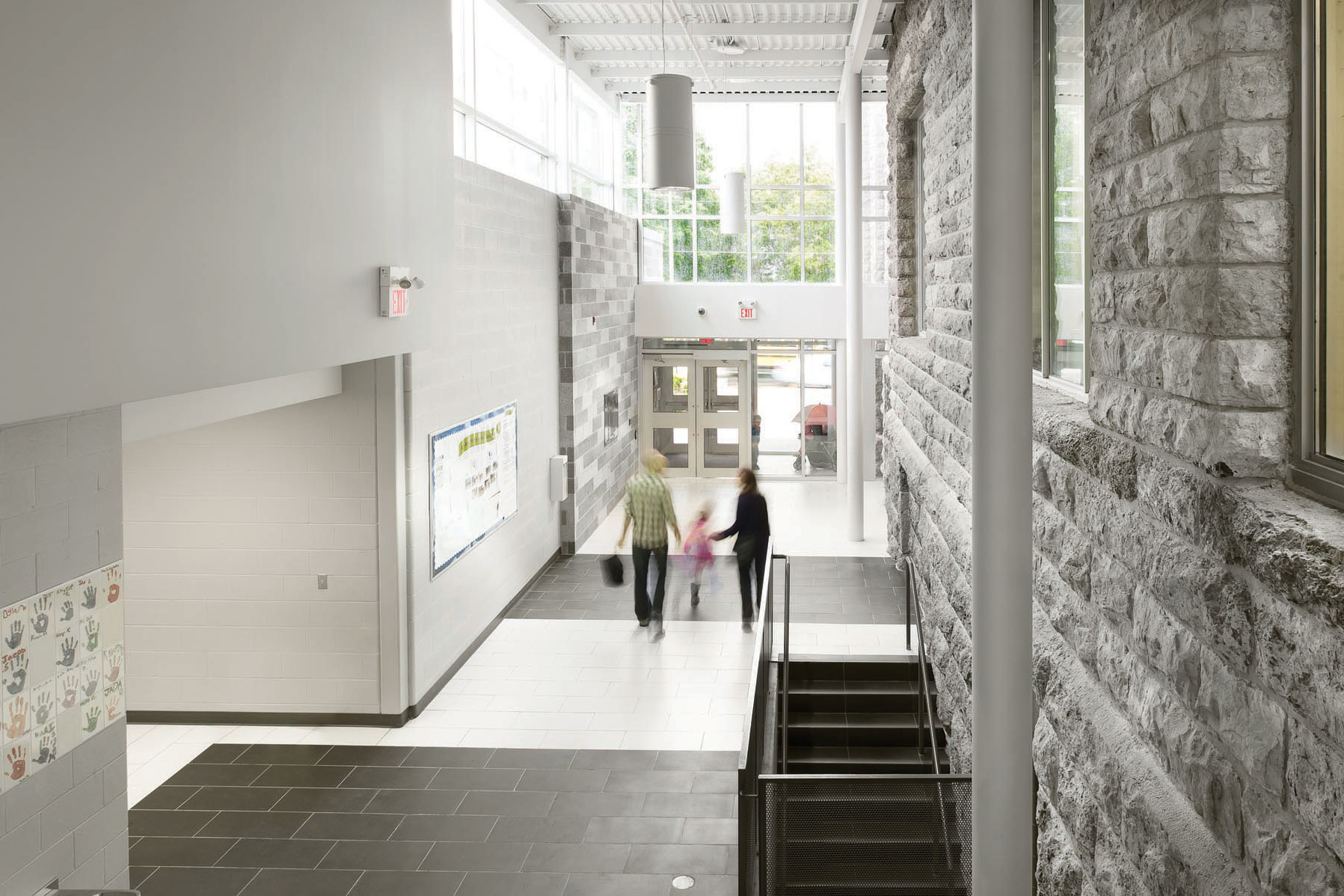 Double height entrance corridor showing connection between original stone façade and addition with clerestory windows
