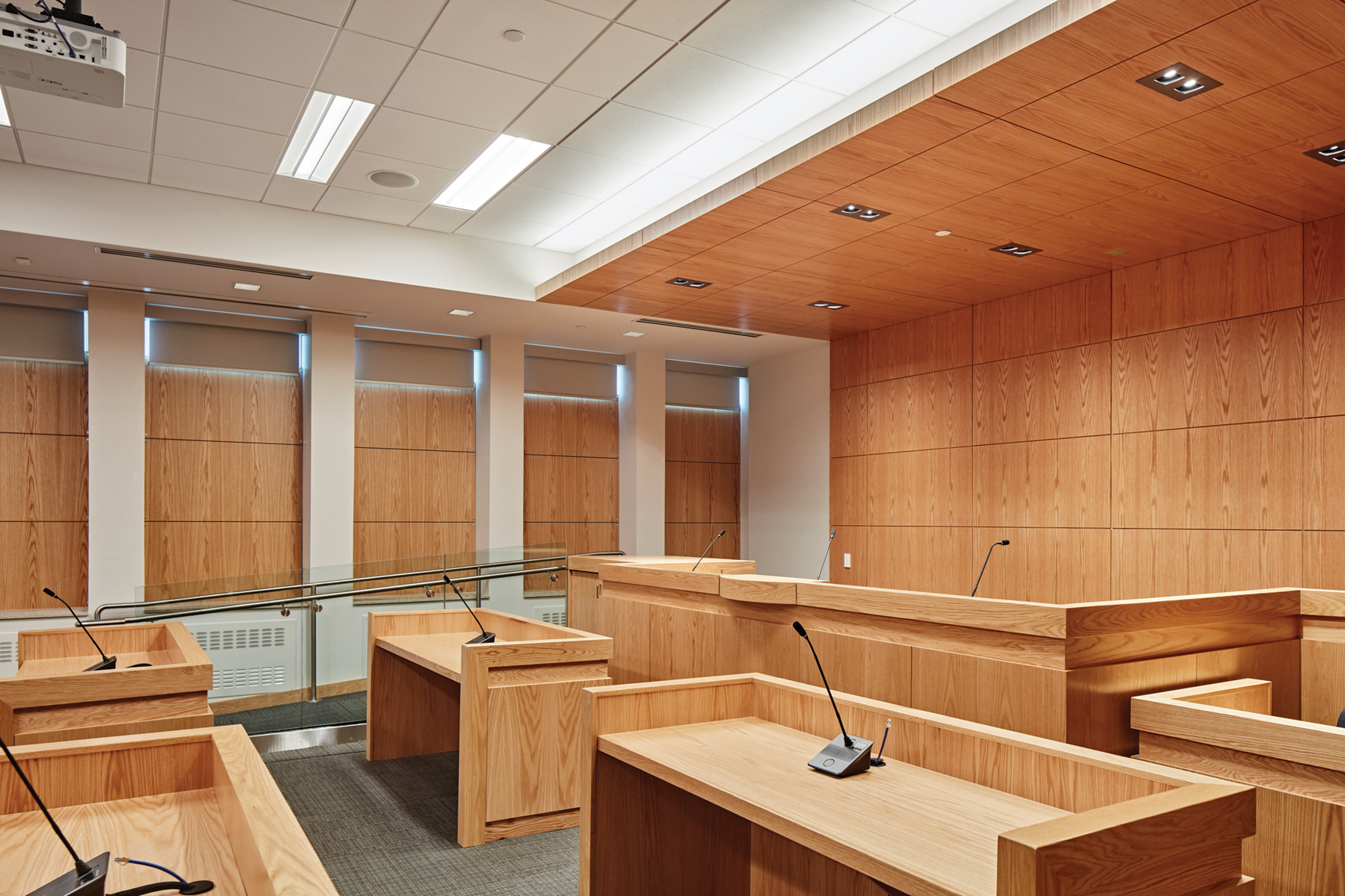 Courtroom with millwork benches for prosecution, defense, judge and witness, with wood paneling on walls