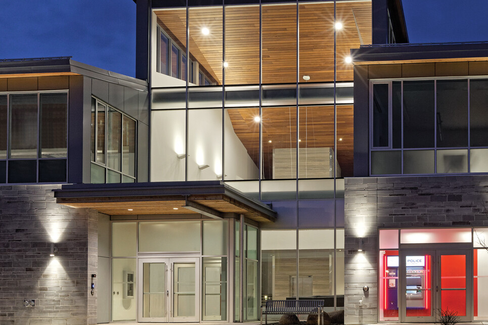 Exterior view of illuminated double height entry lobby at dusk